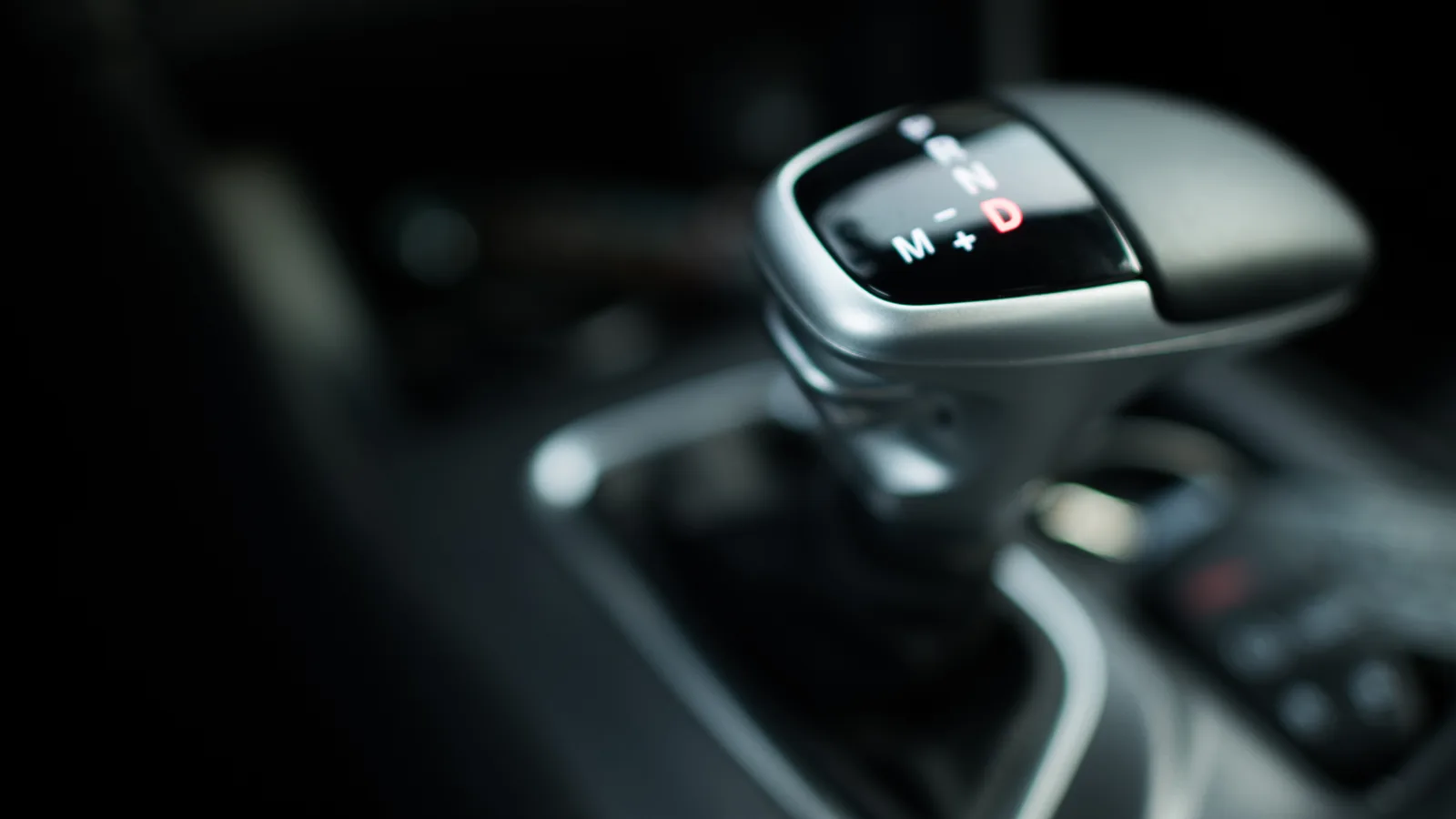 Wybierak automatycznej skrzyni z podświetloną literą D oraz oznaczeniami M, plus i minus